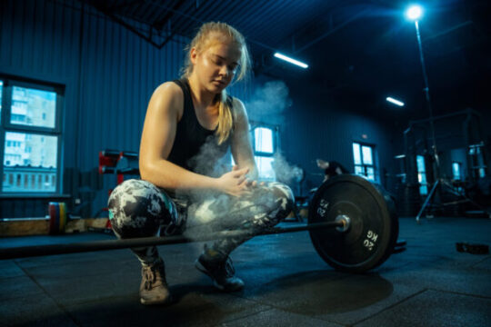 caucasian teenage girl practicing weightlifting gym female sportive model preapring training with barbell looks concentrated body building healthy lifestyle movement action concept