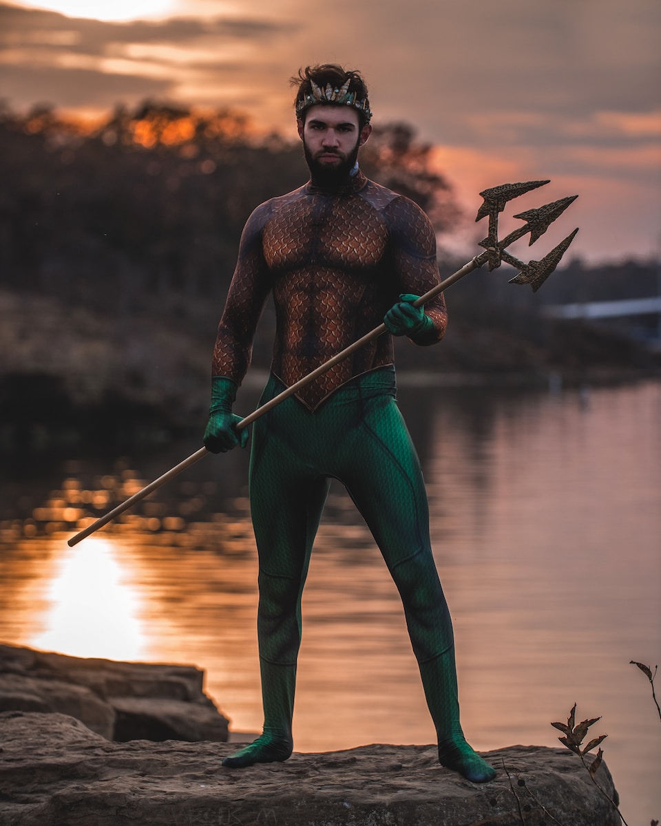 brad piit in troy man wearing Poseidon costume standing on rock