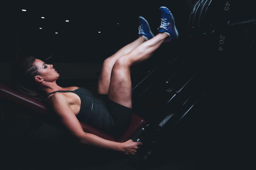 woman working on leg press machine The 30-Minute TRX Leg Workout You Need to Try