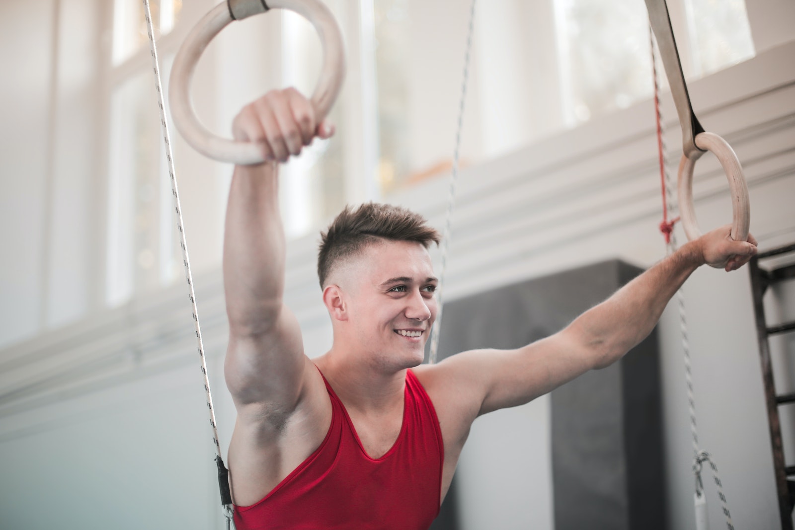Ring Workout Handsome man smiling and holding gymnastic rings