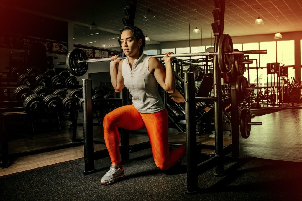 Fitness Center Workouts woman wearing gray shirt and orange leggings